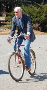 Man in suit riding a bike